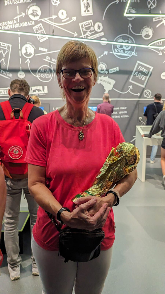 Eine Teilnehmerin hält stolz den WM-Pokal von 1990 im Arm